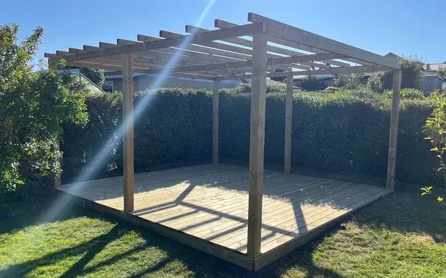 Færdig træterrasse med pergola i en have